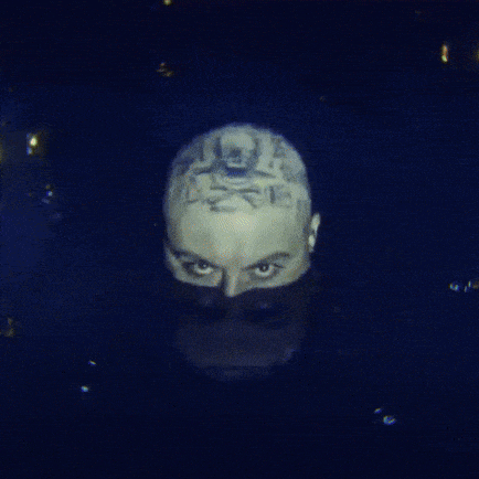 A Close Up Of A Man 'S Face With A Tattoo On It GIF