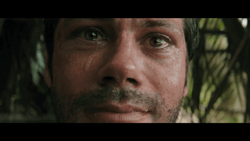 a close up of a man 's face with a tear running down his eye