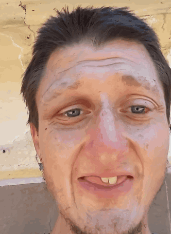 A Close Up Of A Man 'S Face With A Tongue Sticking Out GIF