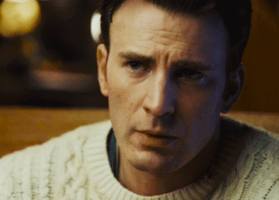 a close up of a man 's face with a white sweater on