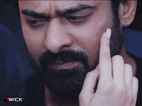 A Close Up Of A Man 'S Face With A Wick Logo On The Bottom GIF