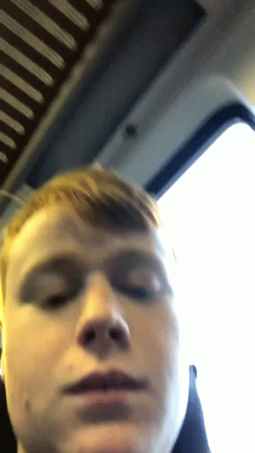 A Close Up Of A Man 'S Face With A Window In The Background GIF