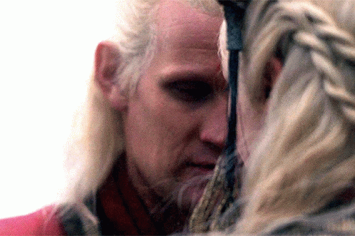 a close up of a man 's face with a woman behind him