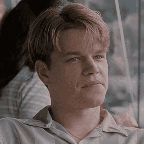 A Close Up Of A Man 'S Face With A Woman 'S Arm Around His Shoulder GIF