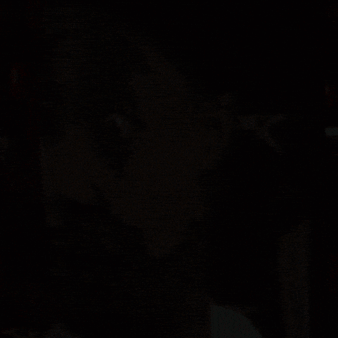 A Close Up Of A Man 'S Face With An X On The Back Of A Chair GIF