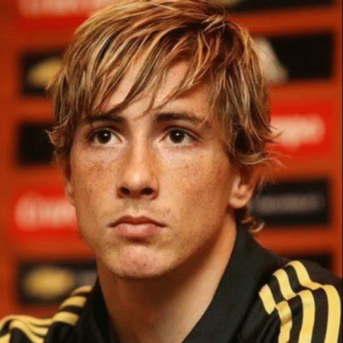 A Close Up Of A Man 'S Face With Blonde Hair And Freckles Wearing A Black And Yellow Adidas Shirt . GIF