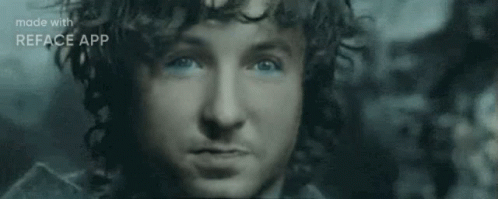 A Close Up Of A Man 'S Face With Blue Eyes And A Beard . GIF