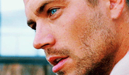 A Close Up Of A Man 'S Face With Blue Eyes And A Beard GIF