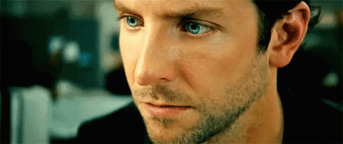 A Close Up Of A Man 'S Face With Blue Eyes And A Beard . GIF