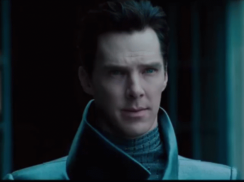 A Close Up Of A Man 'S Face With Blue Eyes And A Black Background GIF