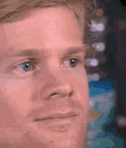 A Close Up Of A Man 'S Face With Blue Eyes Looking At Something . GIF