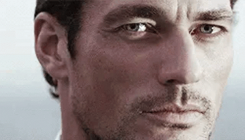 A Close Up Of A Man 'S Face With Blue Eyes Looking At The Camera . GIF