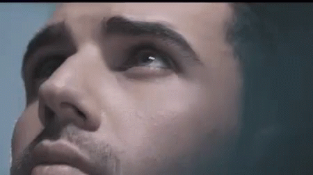 A Close Up Of A Man 'S Face With Blue Eyes Looking Up GIF