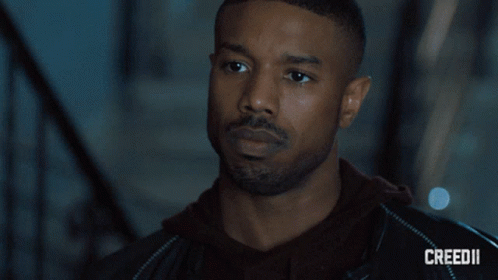 A Close Up Of A Man 'S Face With Creed Ii On The Bottom GIF
