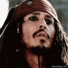 A Close Up Of A Man 'S Face With Dreadlocks And A Bandana On His Head GIF