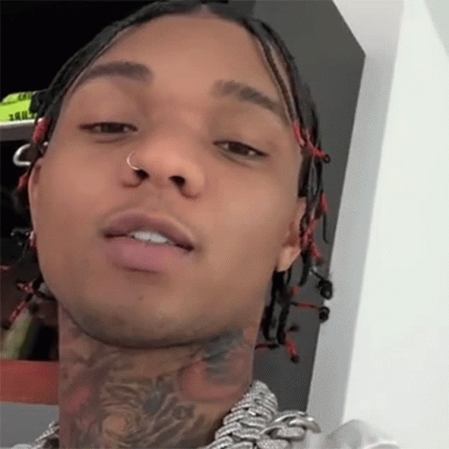 A Close Up Of A Man 'S Face With Dreadlocks And A Tattoo On His Neck GIF