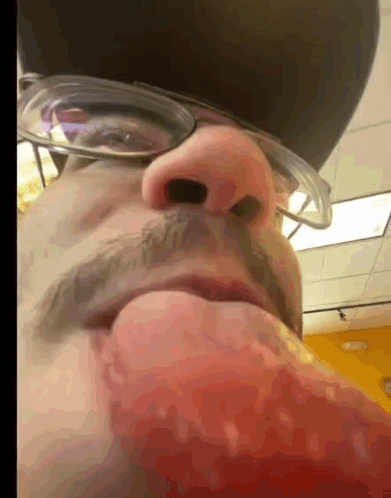 A Close Up Of A Man 'S Face With Glasses And A Hat On GIF