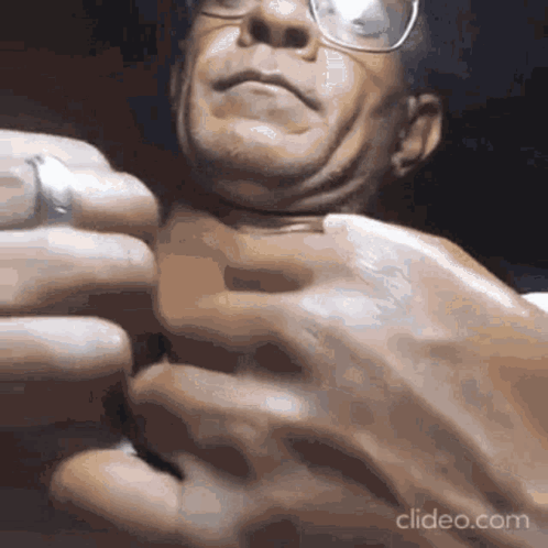 A Close Up Of A Man 'S Face With Glasses Being Squeezed . GIF
