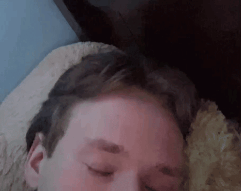 A Close Up Of A Man 'S Face With His Eyes Closed GIF