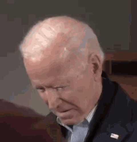 A Close Up Of A Man 'S Face With His Eyes Closed And A Lapel Pin . GIF