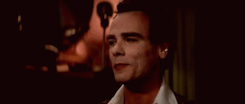 A Close Up Of A Man 'S Face With His Eyes Closed And A Microphone In The Background . GIF