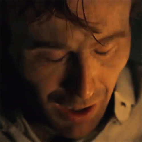 A Close Up Of A Man 'S Face With His Eyes Closed And A Shadow On His Face . GIF