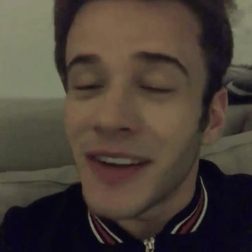 A Close Up Of A Man 'S Face With His Eyes Closed And A Smile On His Face GIF