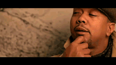 A Close Up Of A Man 'S Face With His Eyes Closed And His Hand On His Chin GIF