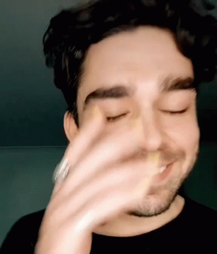 A Close Up Of A Man 'S Face With His Eyes Closed And His Hand On His Face . GIF
