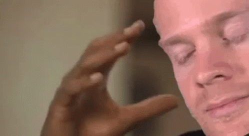 A Close Up Of A Man 'S Face With His Eyes Closed And His Hand On His Head . GIF