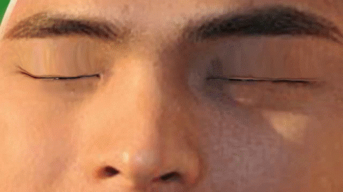 a close up of a man 's face with his eyes closed