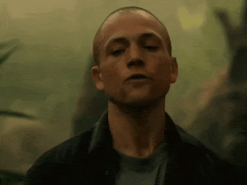 A Close Up Of A Man 'S Face With His Eyes Closed In A Dark Room GIF