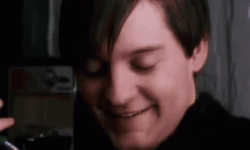 A Close Up Of A Man 'S Face With His Eyes Closed Smiling . GIF