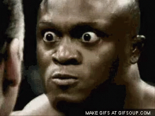 A Close Up Of A Man 'S Face With His Eyes Wide Open Looking At Another Man . GIF