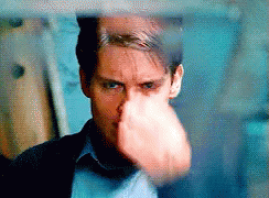 A Close Up Of A Man 'S Face With His Fist In The Air . GIF