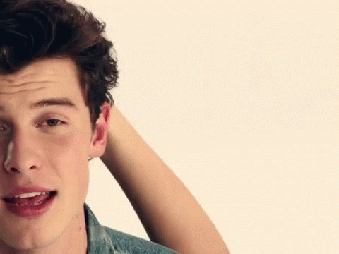 A Close Up Of A Man 'S Face With His Hand In His Hair GIF