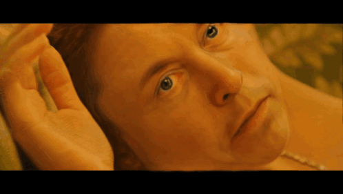 a close up of a man 's face with his hand on his face