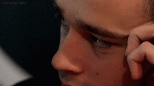 A Close Up Of A Man 'S Face With His Hand On His Face . GIF