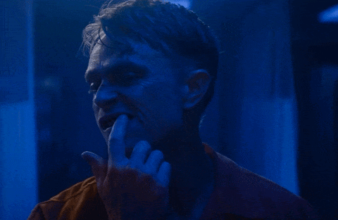 A Close Up Of A Man 'S Face With His Hand On His Mouth GIF