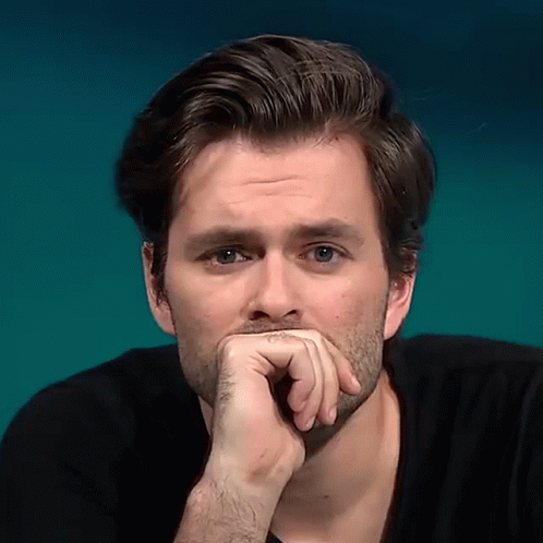 A Close Up Of A Man 'S Face With His Hand On His Mouth GIF