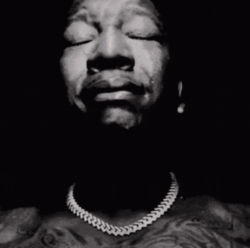 A Close Up Of A Man 'S Face With His Hands Folded In Prayer GIF