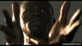 A Close Up Of A Man 'S Face With His Hands In The Air . GIF