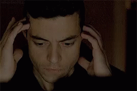 A Close Up Of A Man 'S Face With His Hands On His Head .. GIF