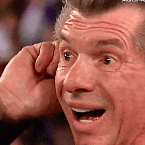A Close Up Of A Man 'S Face With His Mouth Open And His Hand Covering His Ear . GIF