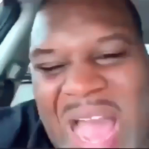 A Close Up Of A Man 'S Face With His Tongue Hanging Out . GIF