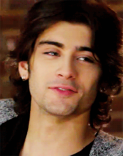 A Close Up Of A Man 'S Face With Long Hair And Earrings GIF