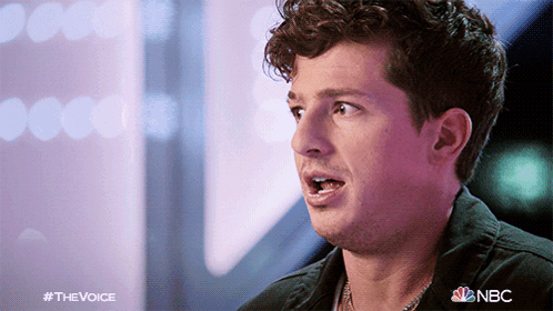 A Close Up Of A Man 'S Face With The Nbc Logo In The Background GIF