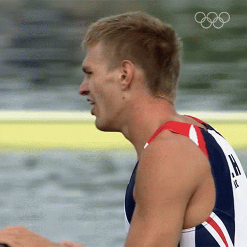 A Close Up Of A Man 'S Face With The Olympic Rings Visible GIF