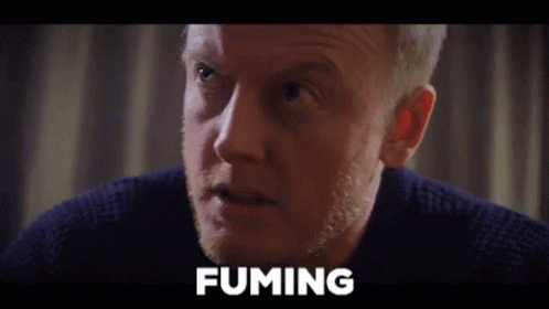 A Close Up Of A Man 'S Face With The Word Fuming Written Above Him GIF