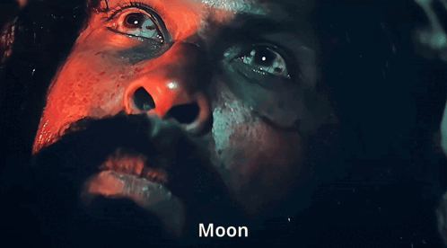 a close up of a man 's face with the word moon on the bottom right